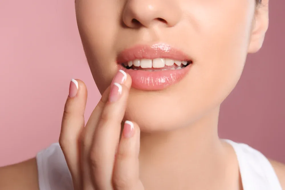A client touches her healed lips after completing permanent makeup recovery.
