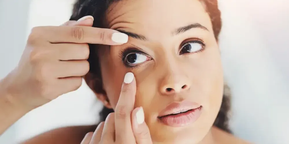 A woman checks her eye with concern, illustrating the user's full responsibility for safety when using unregulated DIY lash kits.