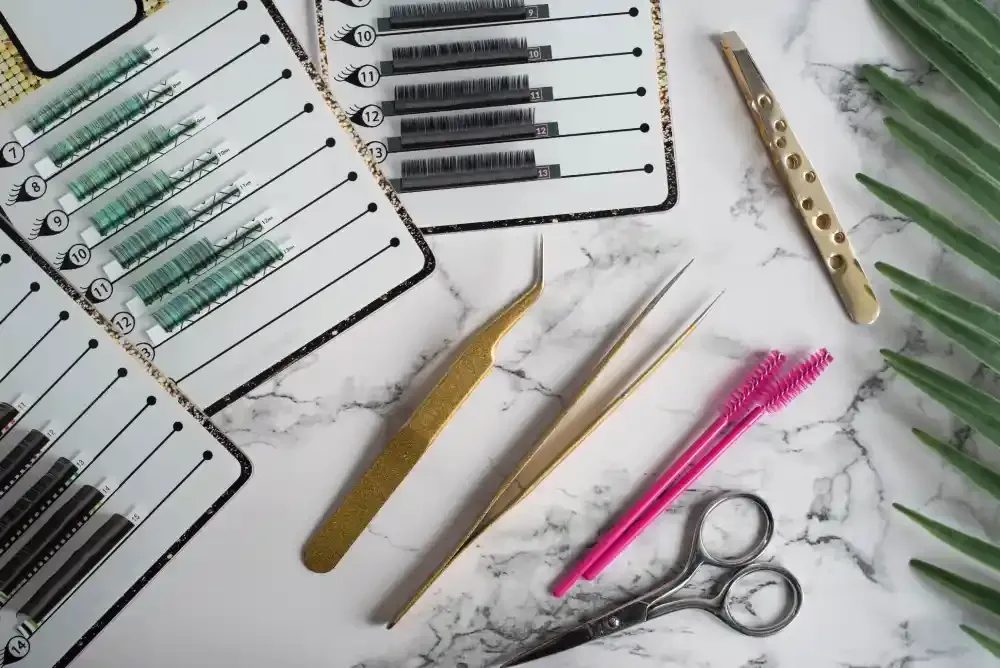 A collection of professional lash extension supplies on a marble background, representing the industry's move toward eco-friendly solutions.