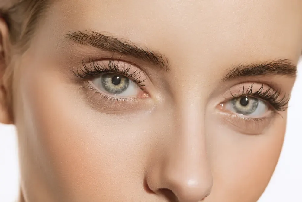 A woman's face showcasing the enhanced length and density that is the typical visual result of an eyelash extension service.