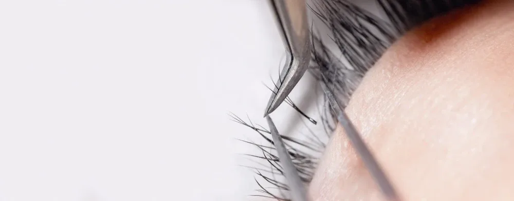 Macro view of healthy natural lashes with neatly applied extensions.