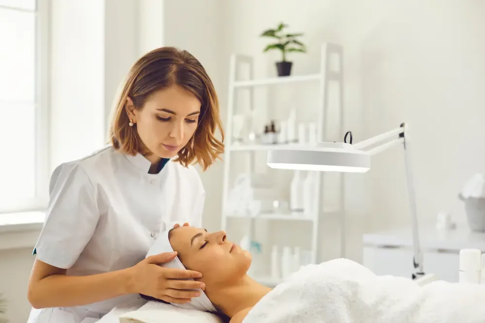 A professional technician assesses a client's skin before a procedure, representing the informed choice of a safe salon service over a DIY kit.