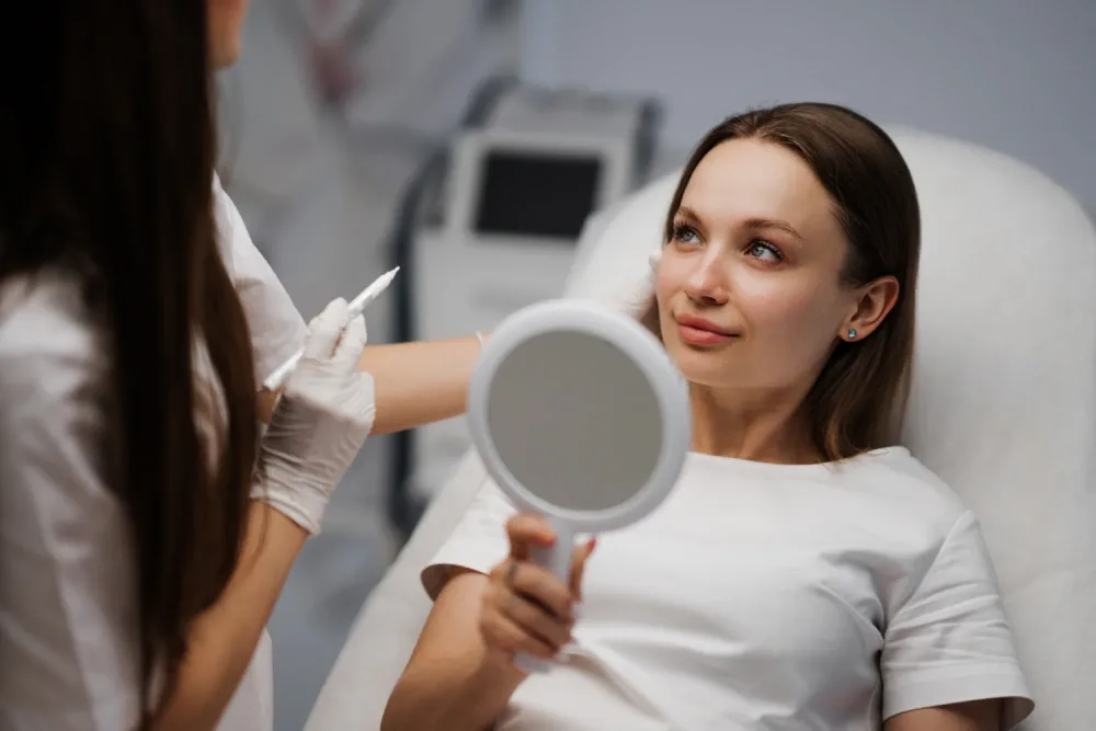 A technician and client discuss allergies and a lash-adhesive patch test.