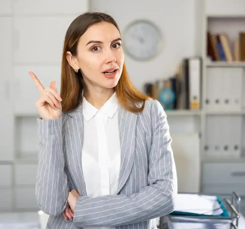 A professional esthetician points her finger up, explaining the list of medical contraindications for eyelash extensions.