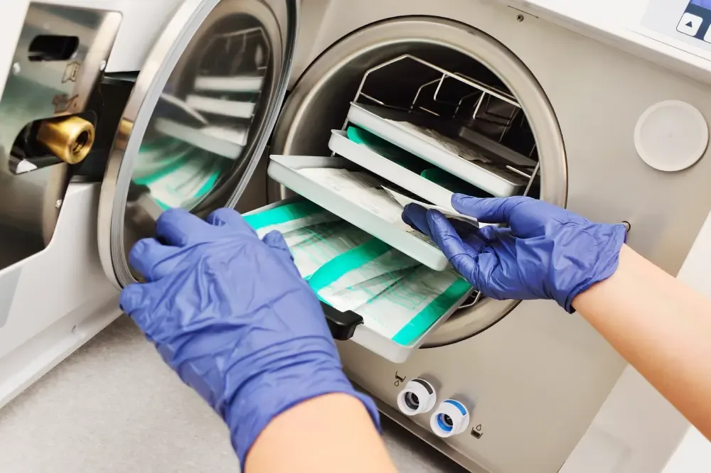 A technician loads packaged instruments into a sterilizer.