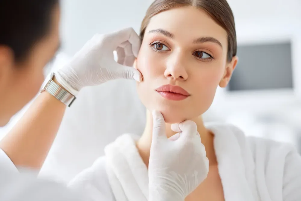 A licensed technician examines a client's face, illustrating the critical role of an experienced master in ensuring lip tattooing safety.