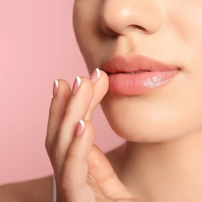 A close-up of a woman's lips, which appear fuller and healthier, demonstrating the plumping illusion of lip blushing without fillers.