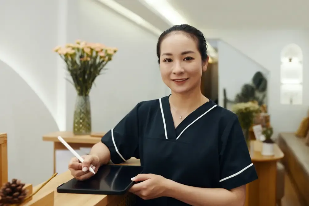 A professional and friendly lip tattoo artist stands at her salon's reception, representing the value and security reflected in the service's price.