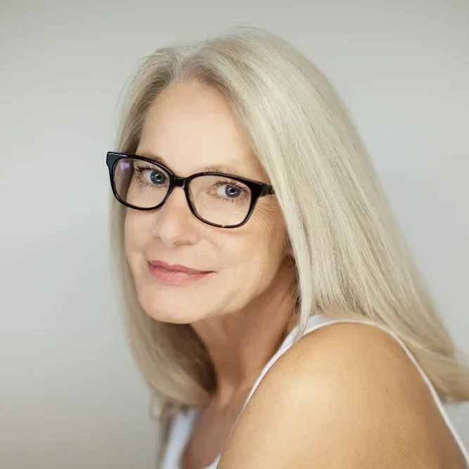 A mature woman with glasses, illustrating how lip blushing can restore youthful color and conceal imperfections on the lips.
