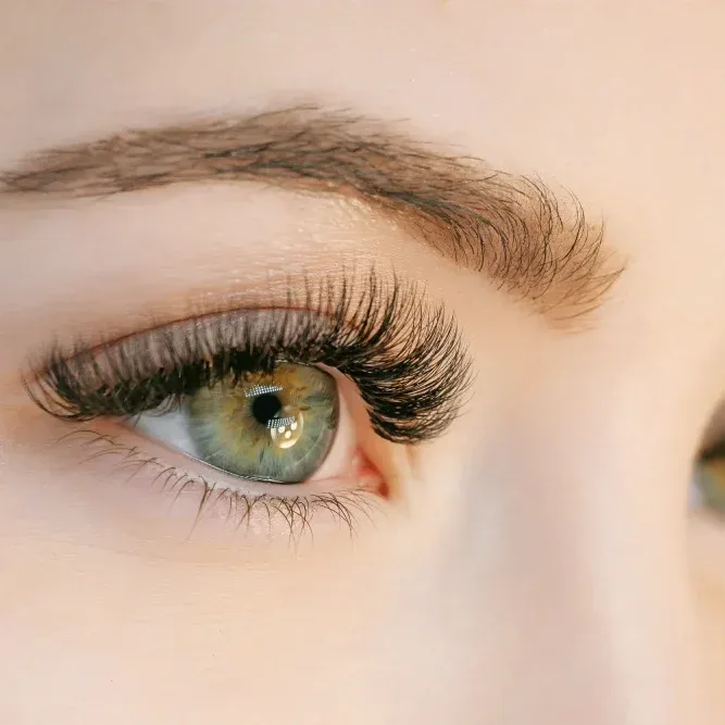 Model wearing photogenic volume lashes with a wet-effect finish.
