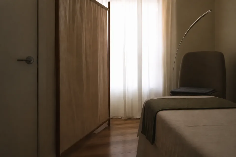 Private ANNAZUR treatment room with a closed door, privacy screen, and prepared treatment bed