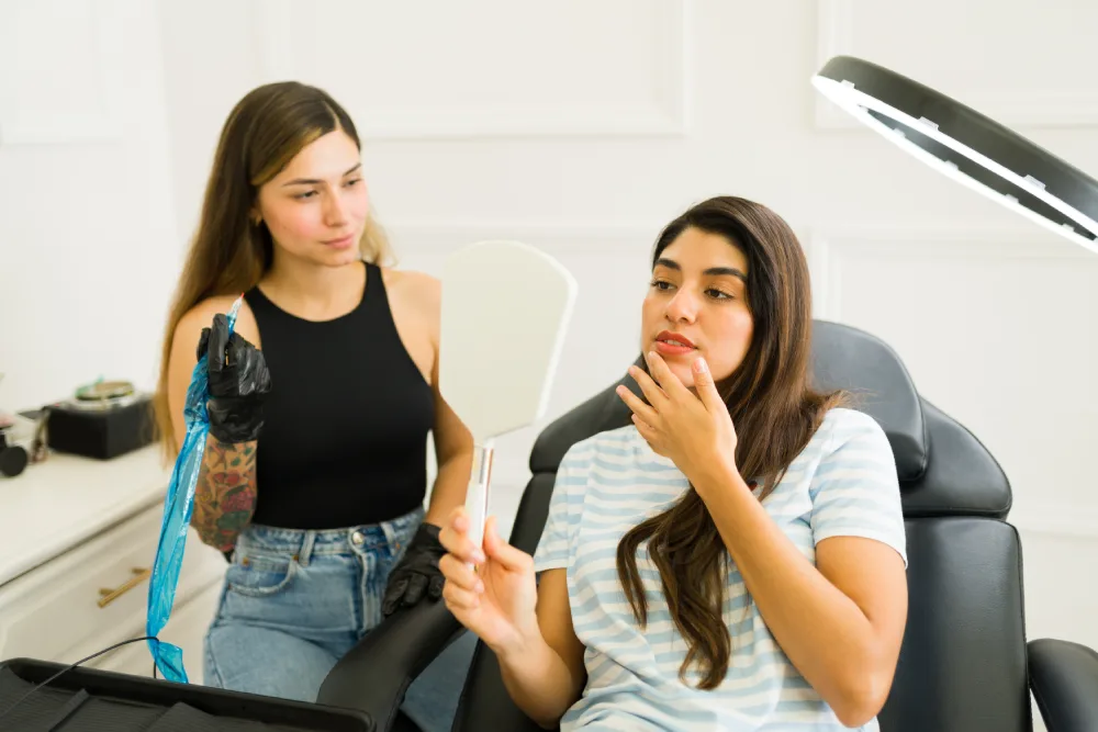 A permanent makeup artist discusses aesthetics, technique, and safety with a client, illustrating why the professional's expertise is the number one factor for results.