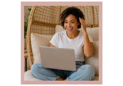 A mulatto woman is at home reading a guide on her laptop about what to expect before her first Brazilian wax, including etiquette, nudity issues, and tipping at a hair removal salon.