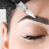 Client getting microblading eyebrow service with precise hair stroke technique for natural effect