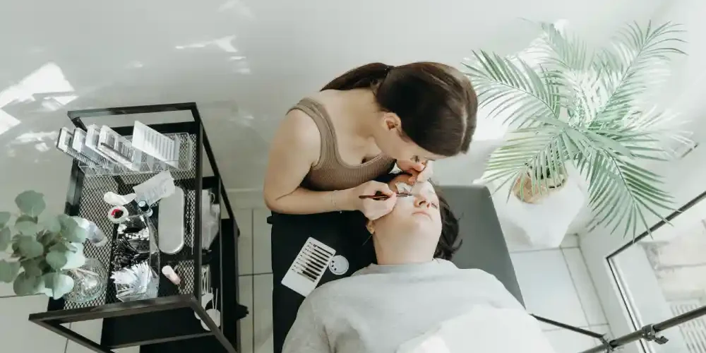 Safety Comparison: Salon vs. Home Lash Application A professional applies eyelash extensions in a clean and controlled salon environment, representing the safety of a salon procedure.