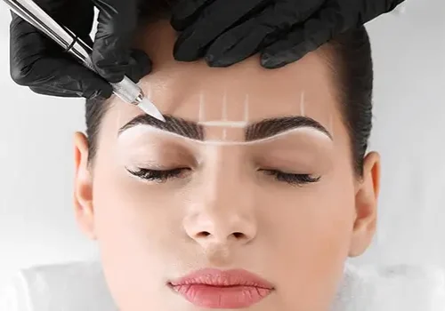 Trainee applying microblading strokes with precision tool on mapped eyebrow, learning professional technique