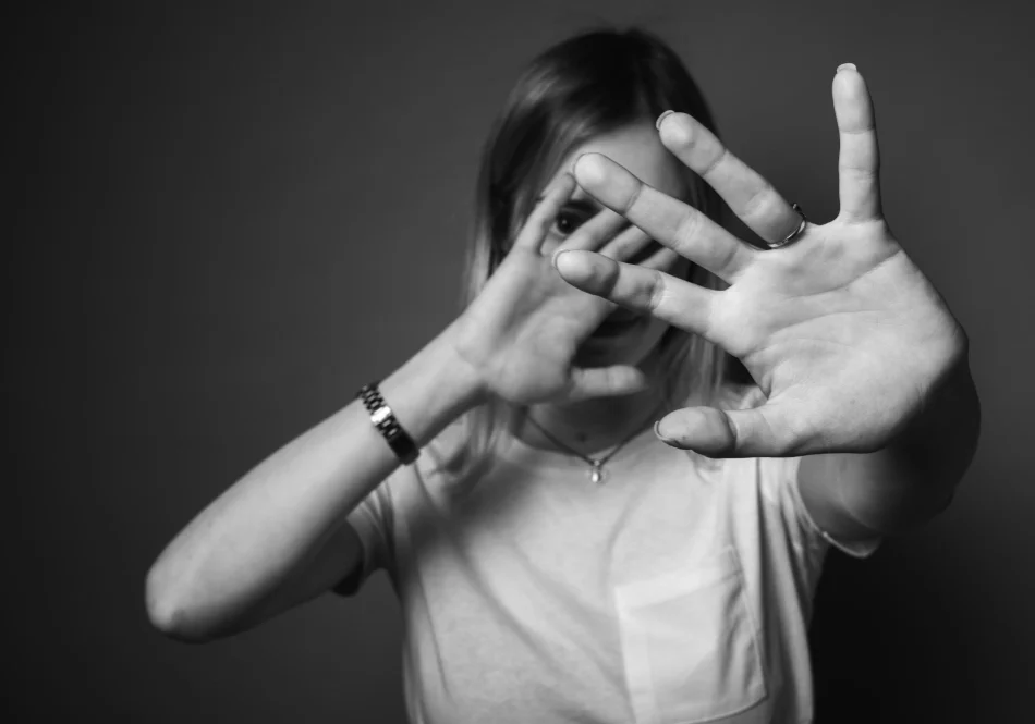 A woman hides her face, representing the social isolation some people feel during the 7-10 day lip tattoo healing process due to swelling and peeling.