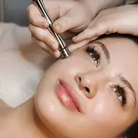 Client receiving gentle microdermabrasion facial treatment with device application for skin renewal