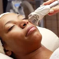 Woman receiving professional acne treatment service with device application for clear skin improvement