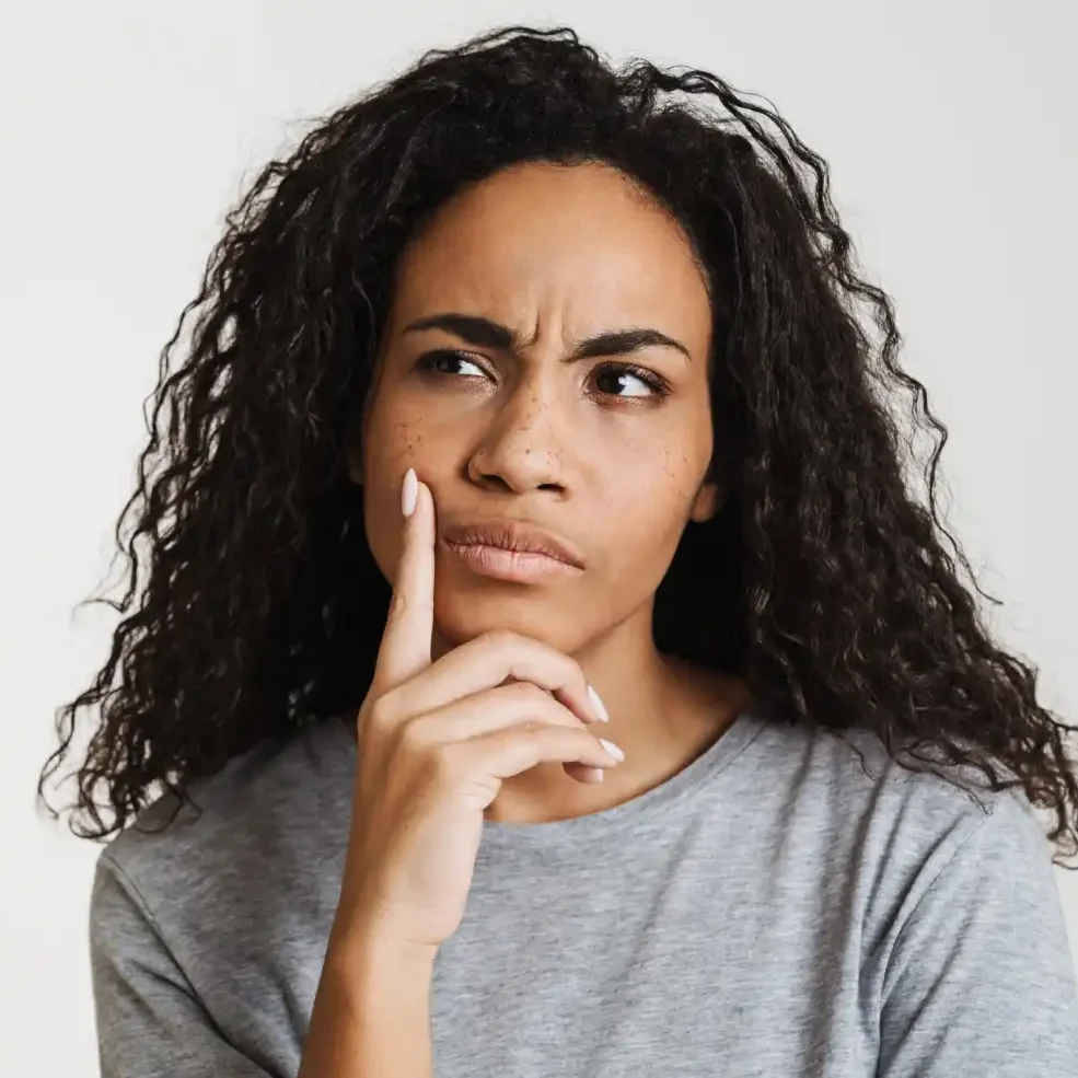 A woman with a thoughtful, skeptical expression, illustrating the moment a client should trust their intuition during a consultation.
