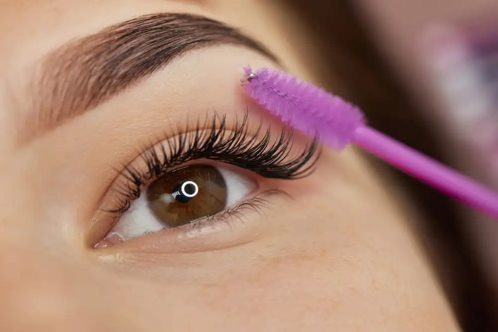 A spoolie brush grooms beautiful eyelash extensions, representing the final result of making a conscious choice of high-quality materials.