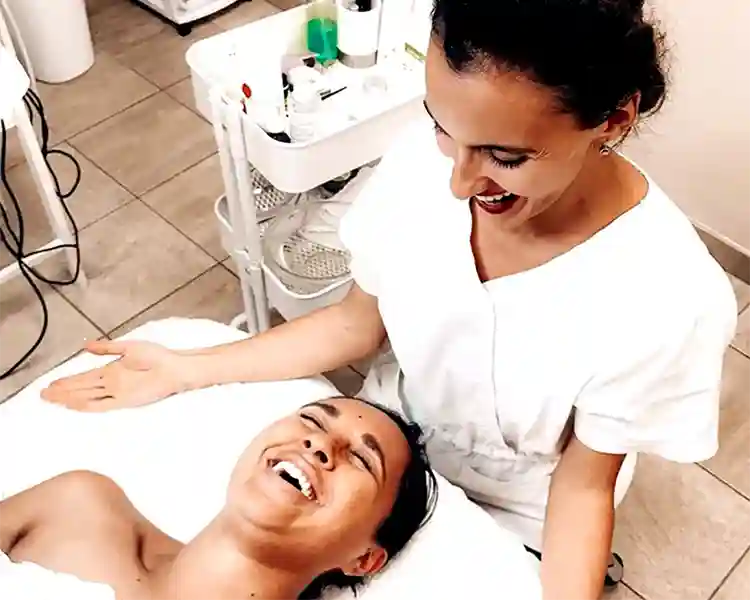 Relaxed client receiving professional facial treatment with caring esthetician Ruzanna, enjoying membership program advantages