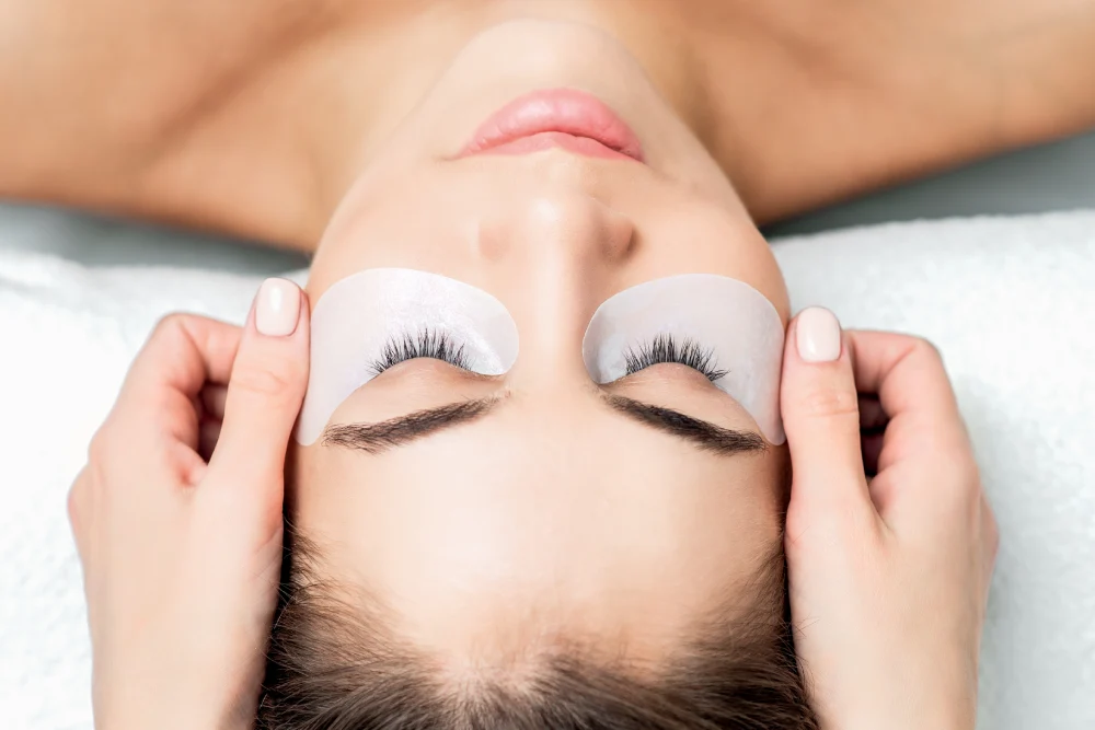 A technician assesses a client's natural lashes to determine the scope of work before an extension application.