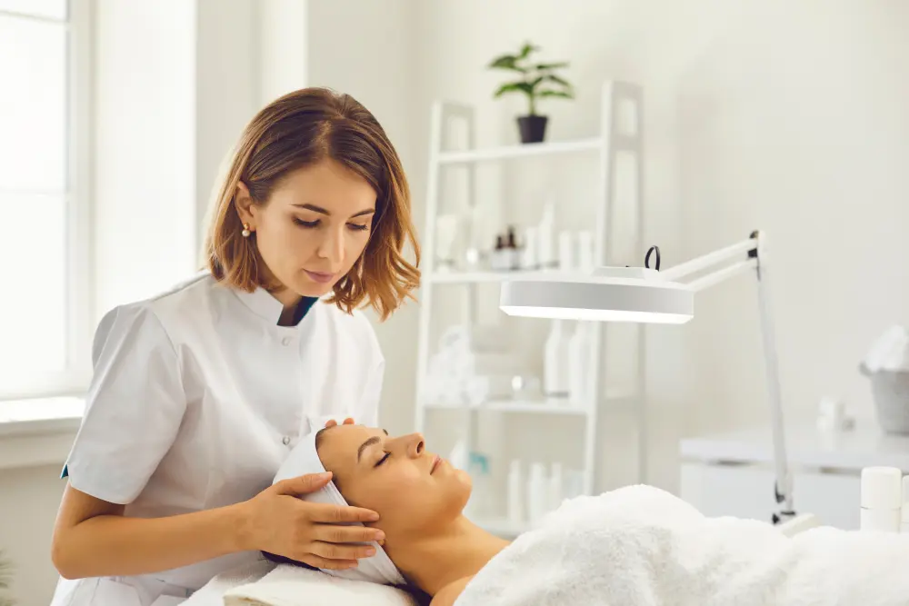 Your Informed Choice Between Salon and DIY A professional technician assesses a client's skin before a procedure, representing the informed choice of a safe salon service over a DIY kit.