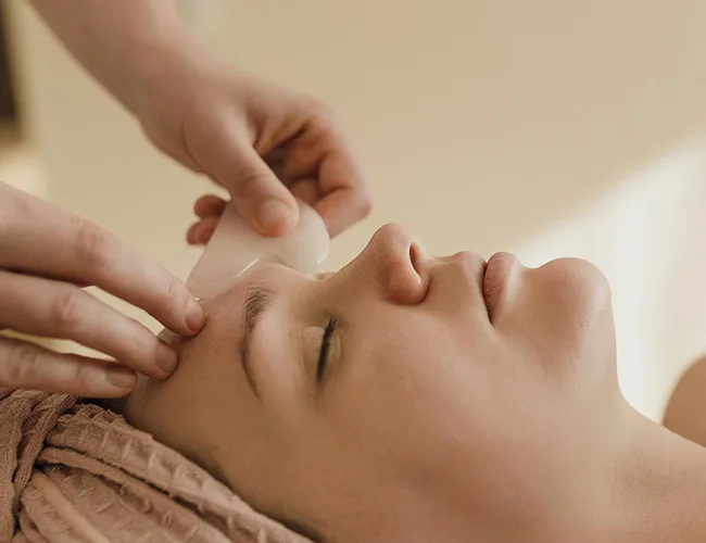Woman getting a Gua Sha Facial Massage