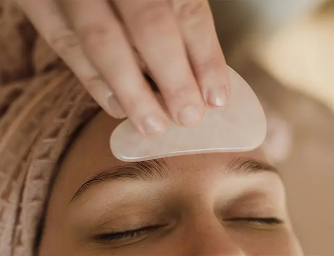 Woman getting a Gua Sha Facial Massage